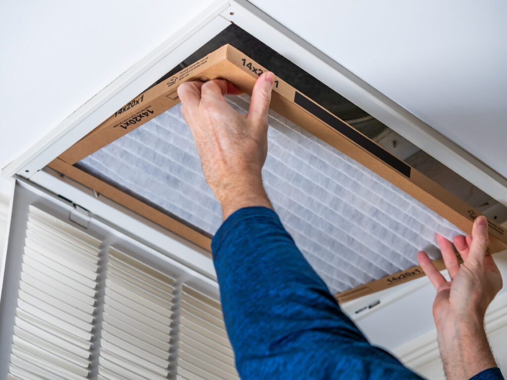 HVAC technician replacing a home air filter in San Juan Capistrano