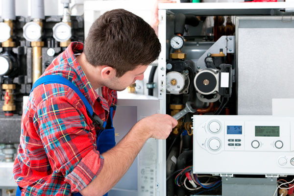 Heating technician repairing boiler controls in San Juan Capistrano