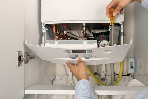 Heating technician repairing a residential boiler in San Juan Capistrano