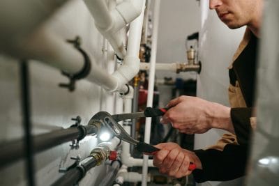 Technician inspecting commercial plumbing pipes in San Juan Capistrano