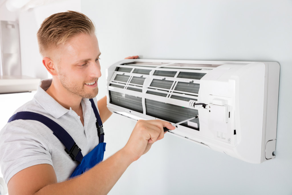 HVAC technician maintaining a ductless air conditioner in San Juan Capistrano