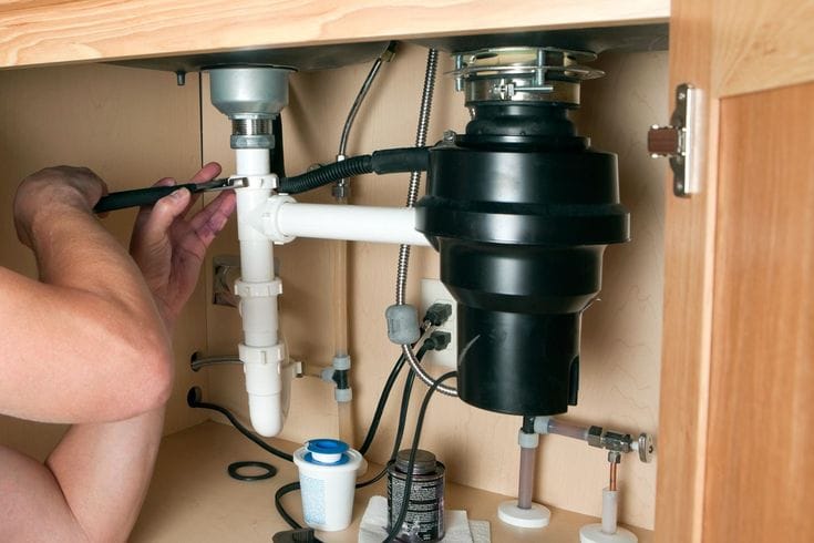 Plumber repairing a garbage disposal in San Juan Capistrano