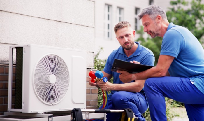 HVAC technicians installing an outdoor air conditioning unit in San Juan Capistrano