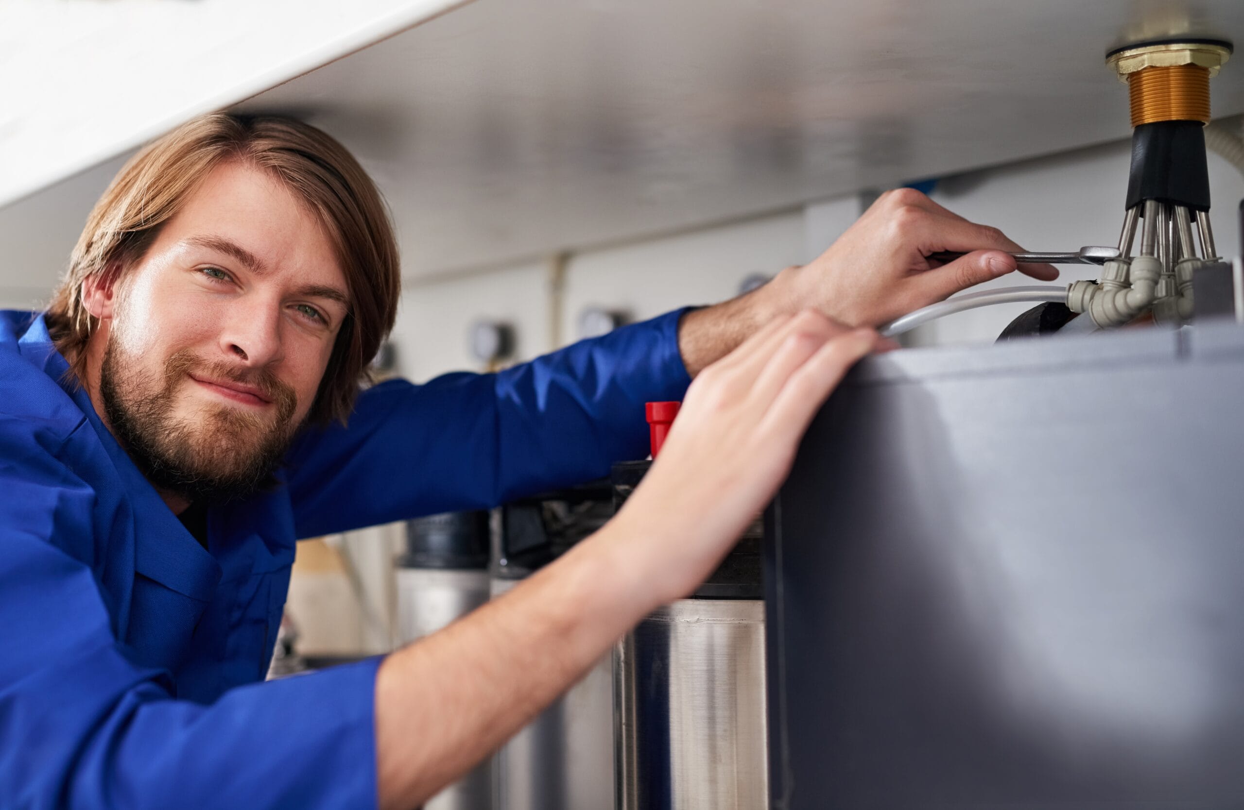 Technician servicing a residential water heater tank in San Juan Capistrano